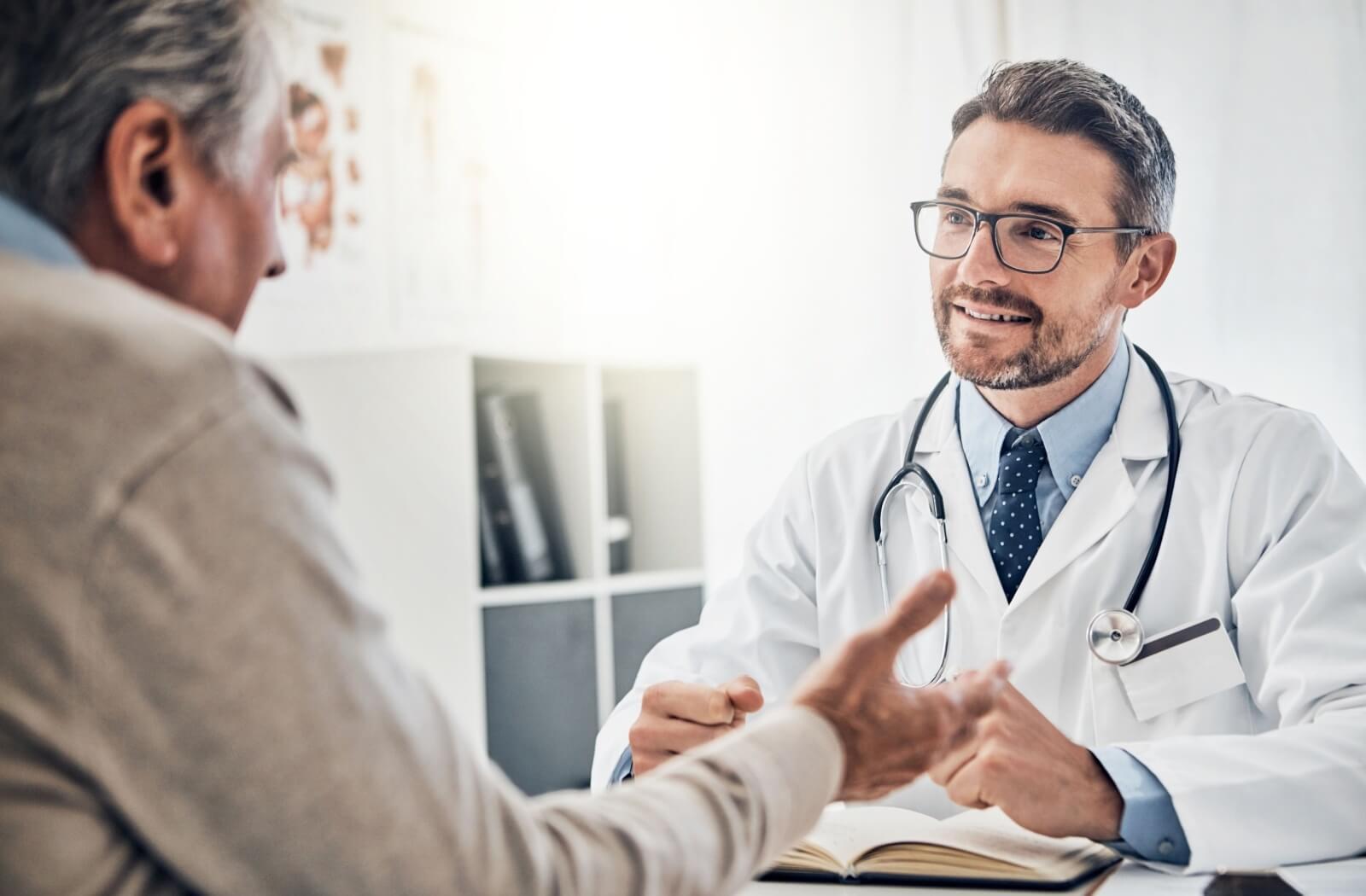 A senior patient speaks with their doctor about their Alzheimer’s disease diagnosis.